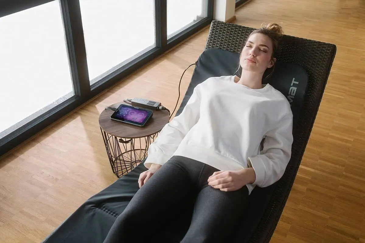 A woman is laying on the floor with her eyes closed.