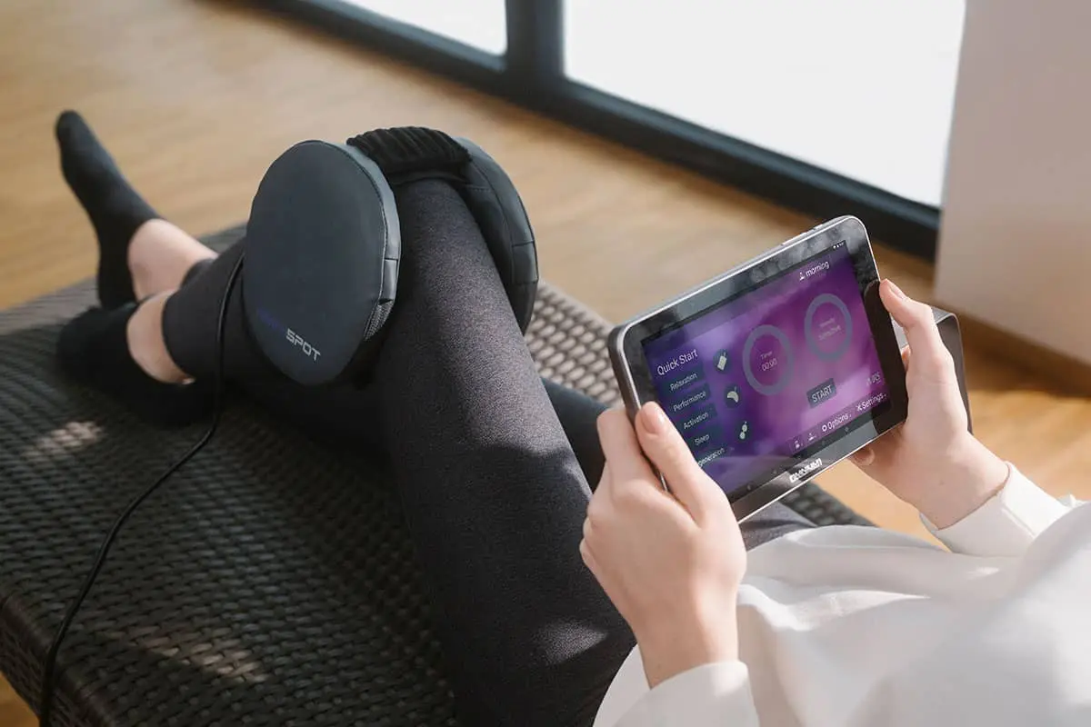 A person sitting on the floor with headphones and tablet.