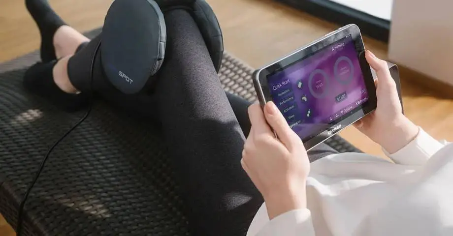 A person sitting on the floor with headphones and tablet.
