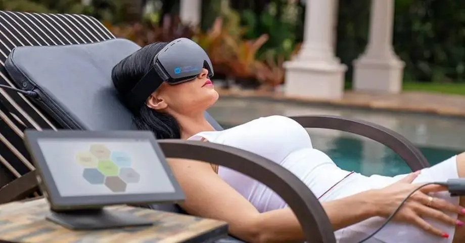 A woman laying on top of a chair with her eyes closed.