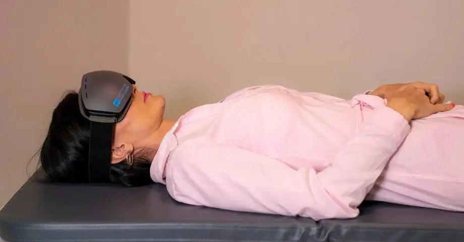 A woman laying on the ground with her eyes closed.