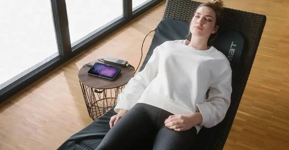 A woman is laying on the floor with her eyes closed.