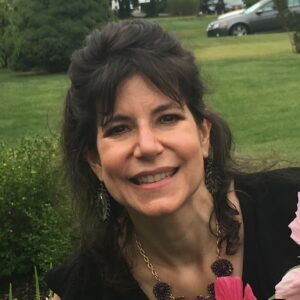 A woman standing in front of some flowers.